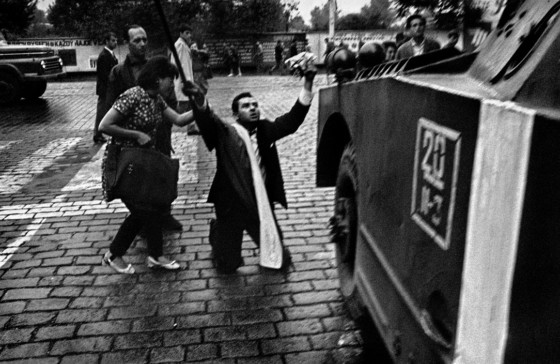 En civil knæler foran et pansret køretøj i Prag fotograferet af Josef Koudelka
